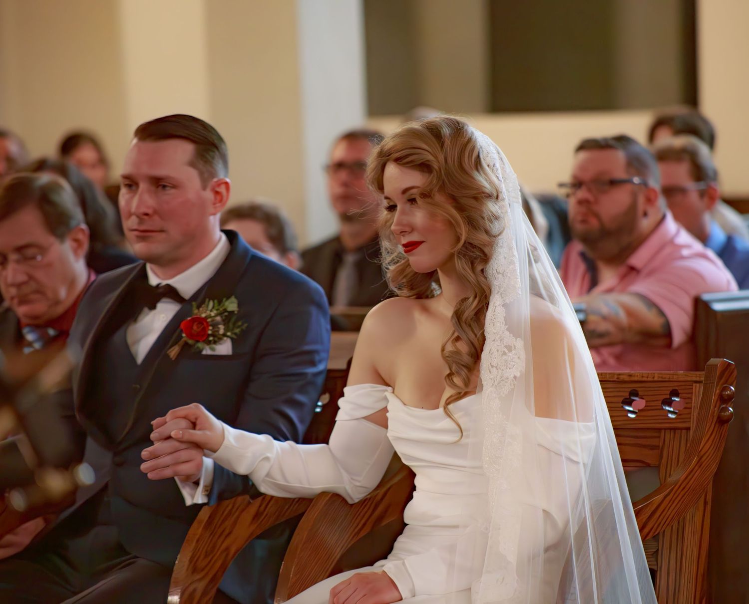 Wedding ceremony attendees seated in wooden pews during traditional church service.
