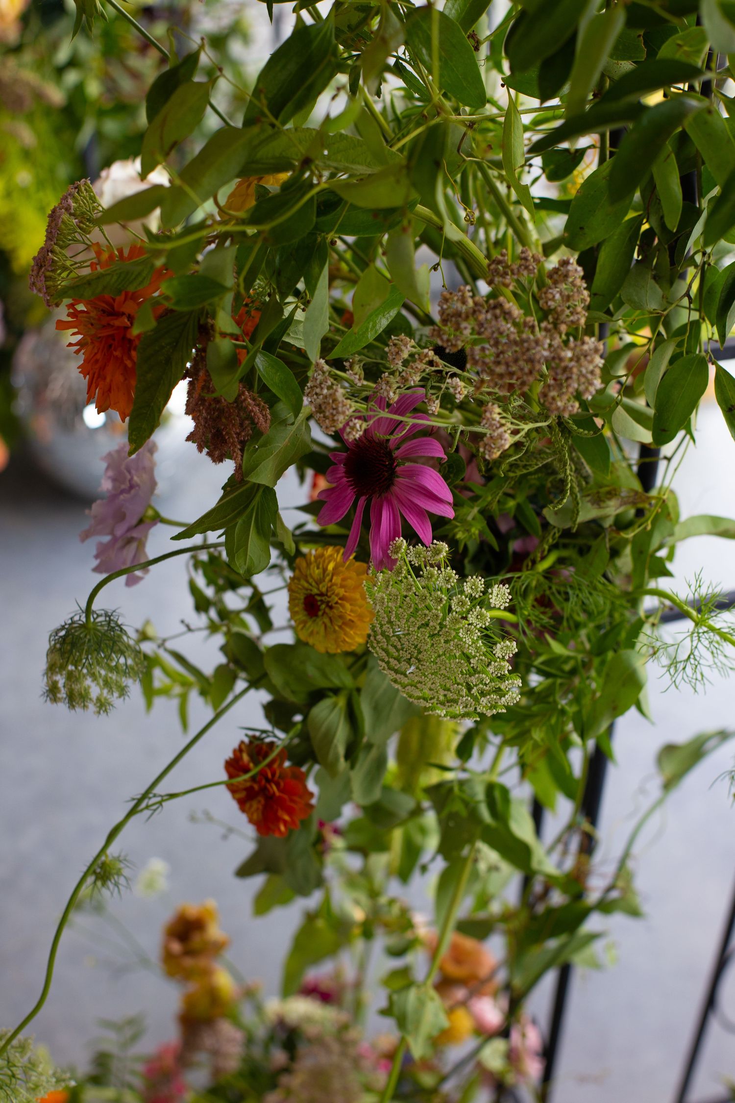 Hanging floral installation with wildflowers and greenery creating a natural garden canopy.