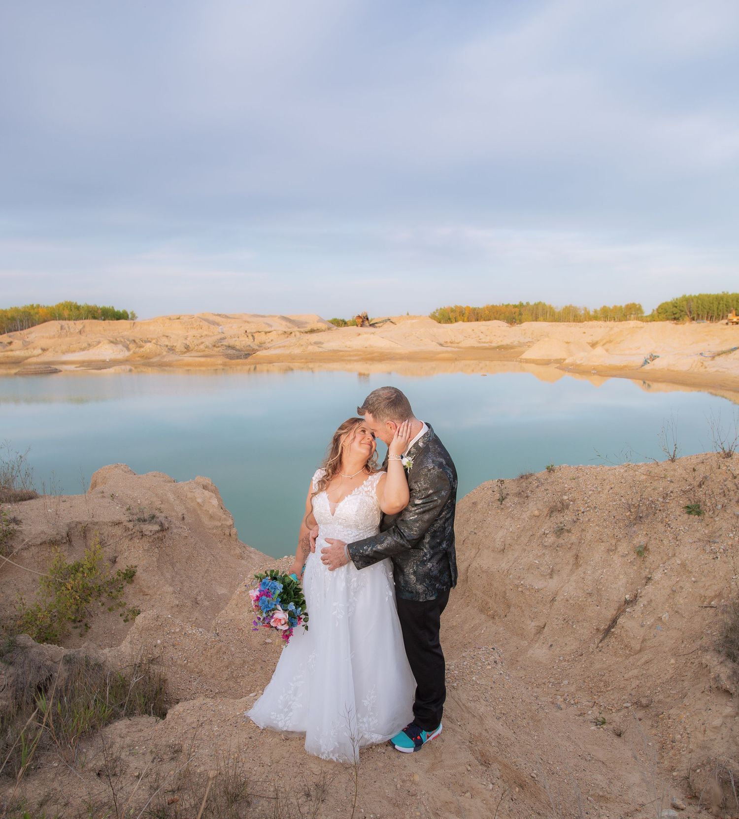 Wedding portraits captured against dramatic cliffs and turquoise water during golden hour.
