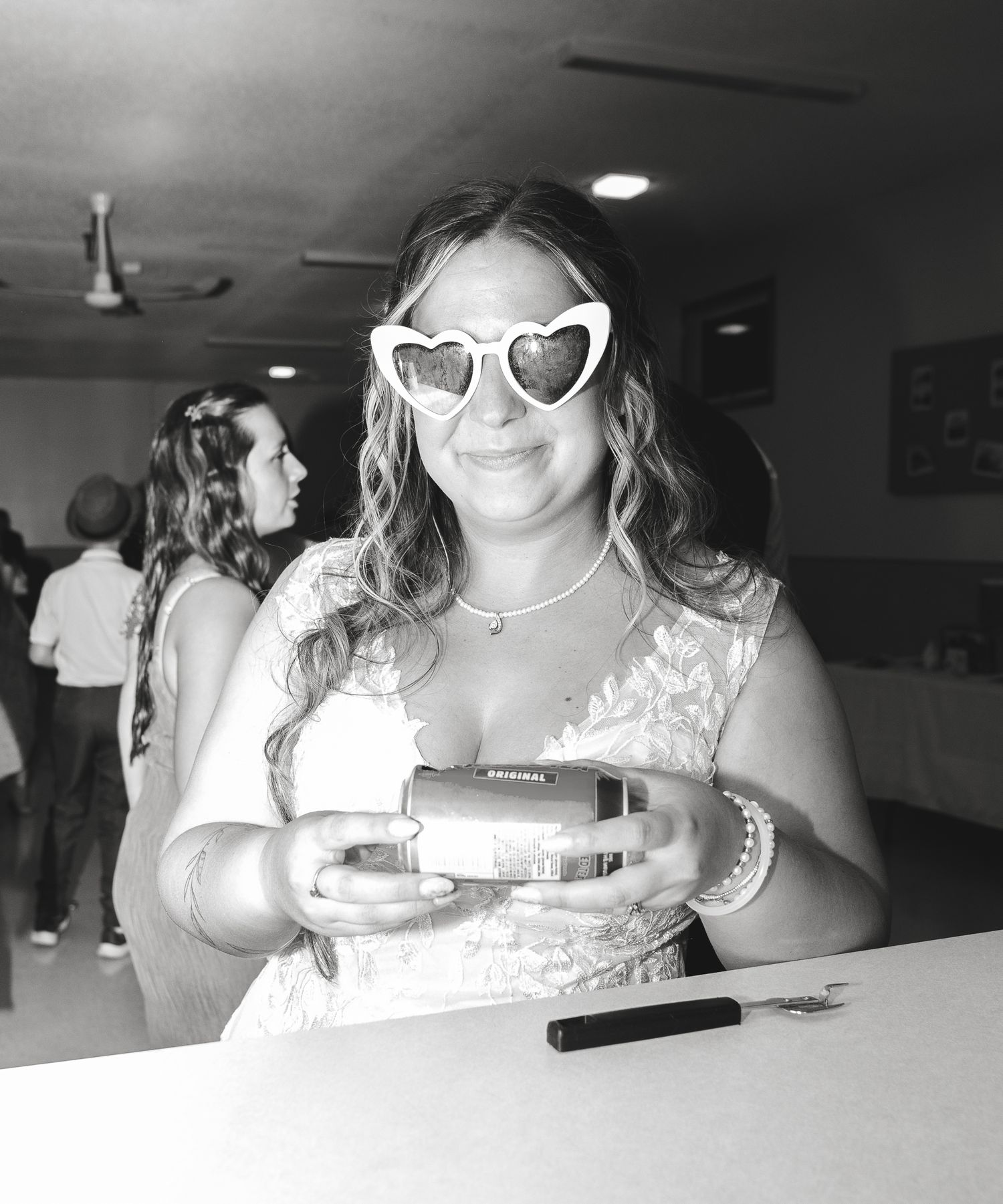 Wedding guests wearing sunglasses and party attire at an indoor celebration.