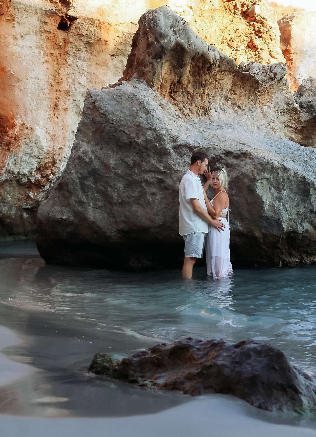 An intimate moment captured between limestone cliffs and crystal clear waters at the beach.