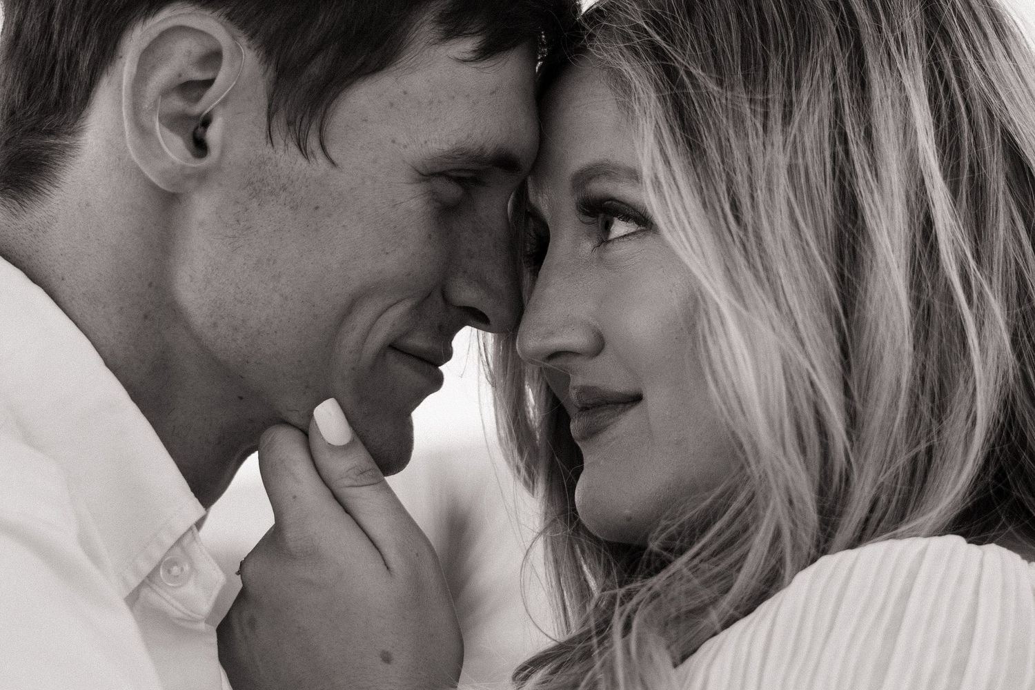 A romantic black and white close-up of a couple sharing an intimate moment.