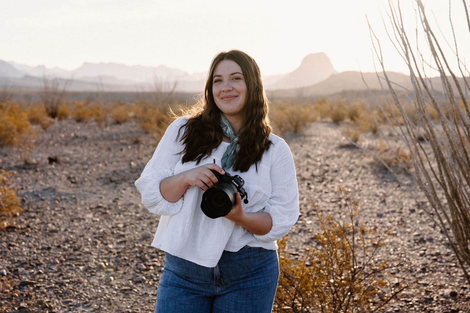 Photographer working in desert landscape during golden hour.