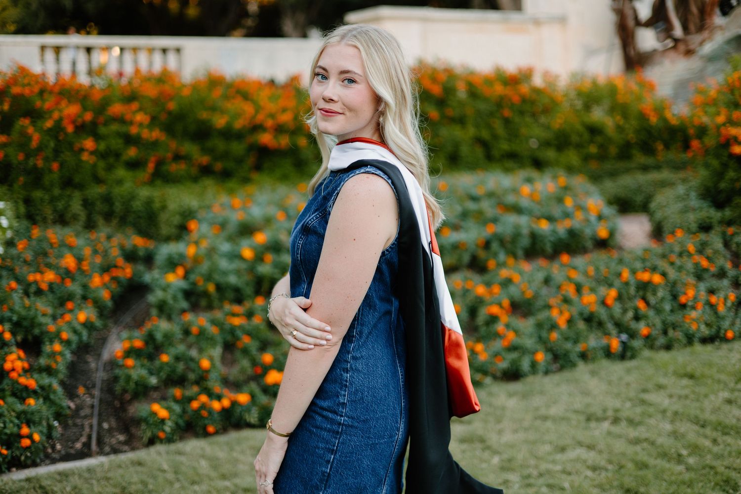 Graduation photo session in field with orange wildflowers.