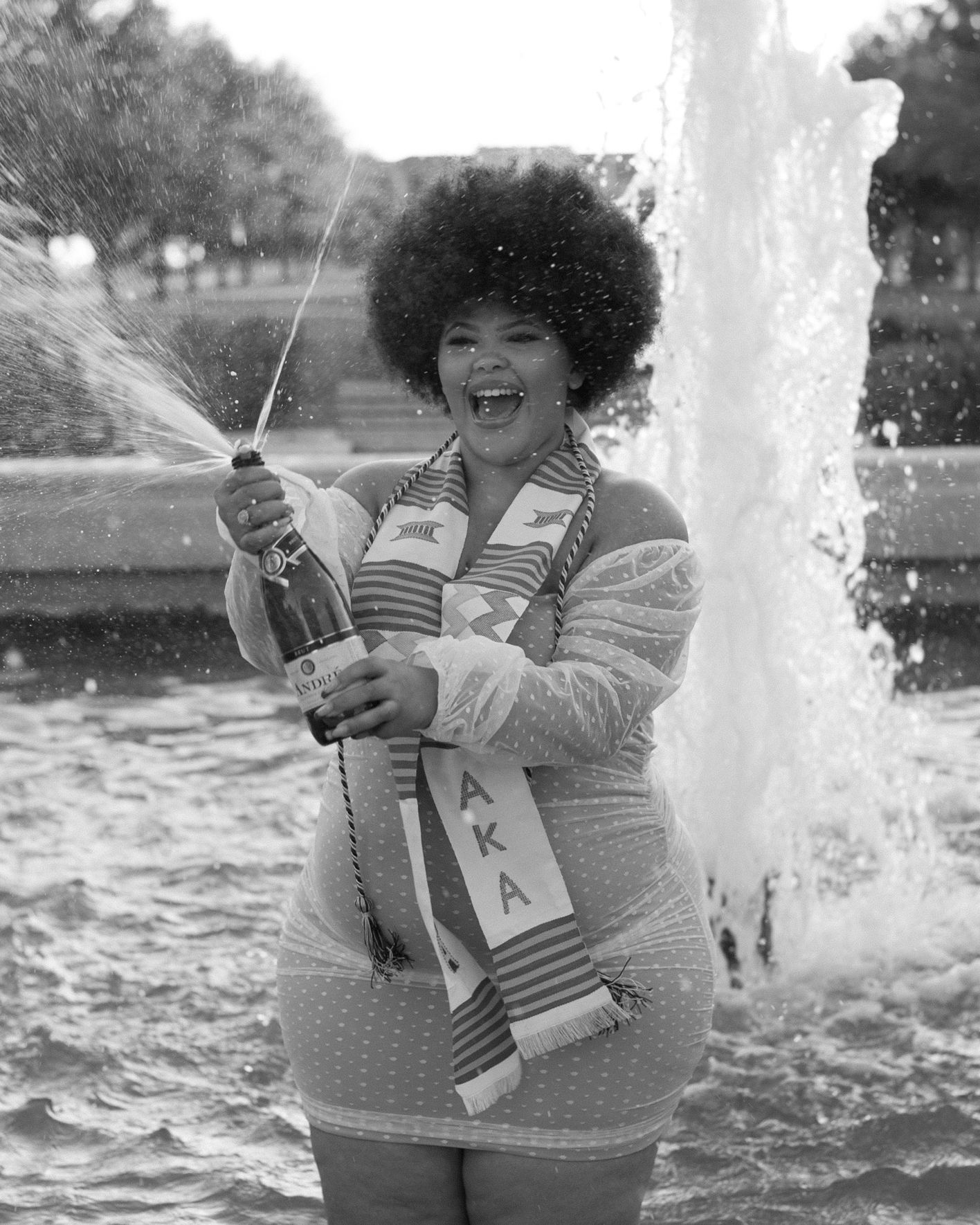Black and white photo series of fun moments by a fountain.