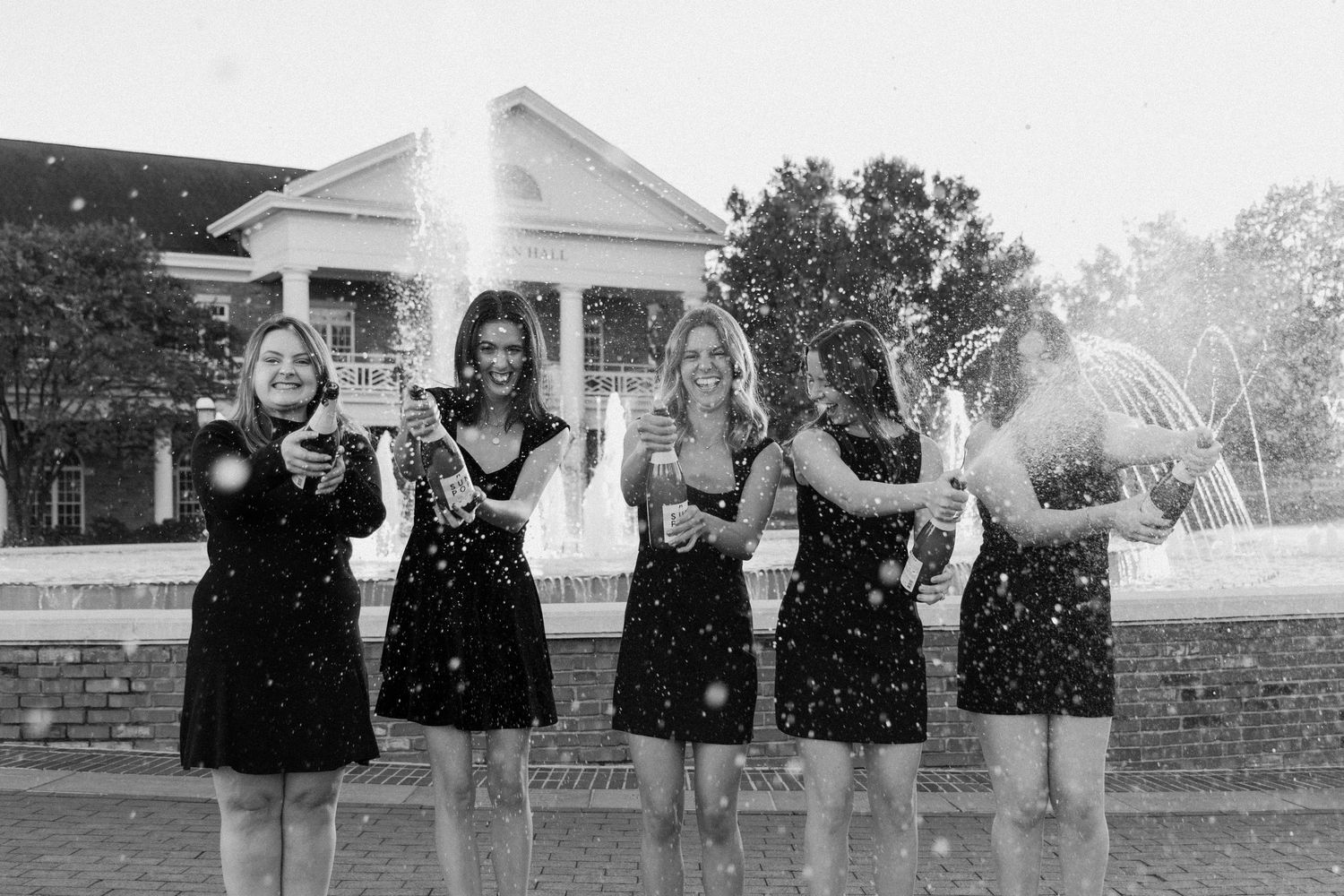 People celebrate with confetti during an outdoor group photo session.