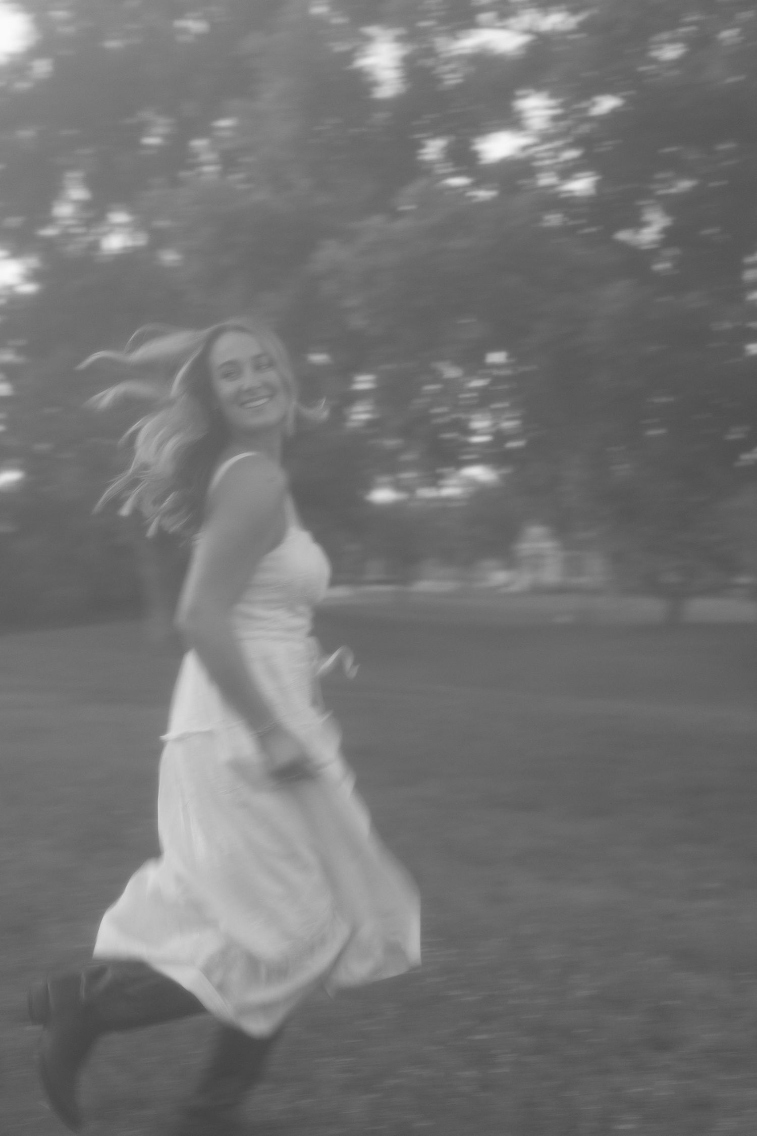 Ethereal black and white photos of someone twirling in a dress outdoors.