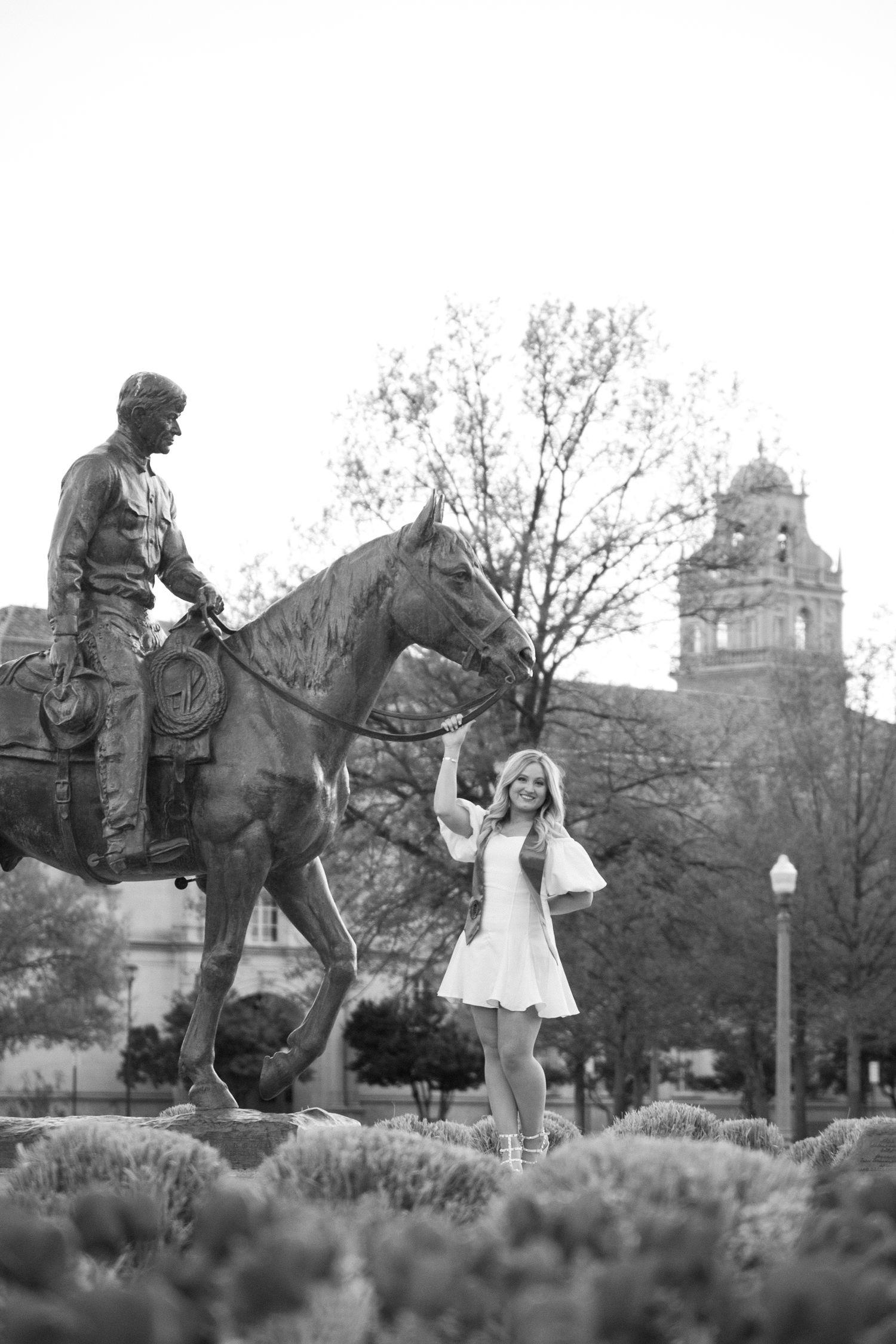 Black and white photos showing playful interaction with a statue on campus grounds.
