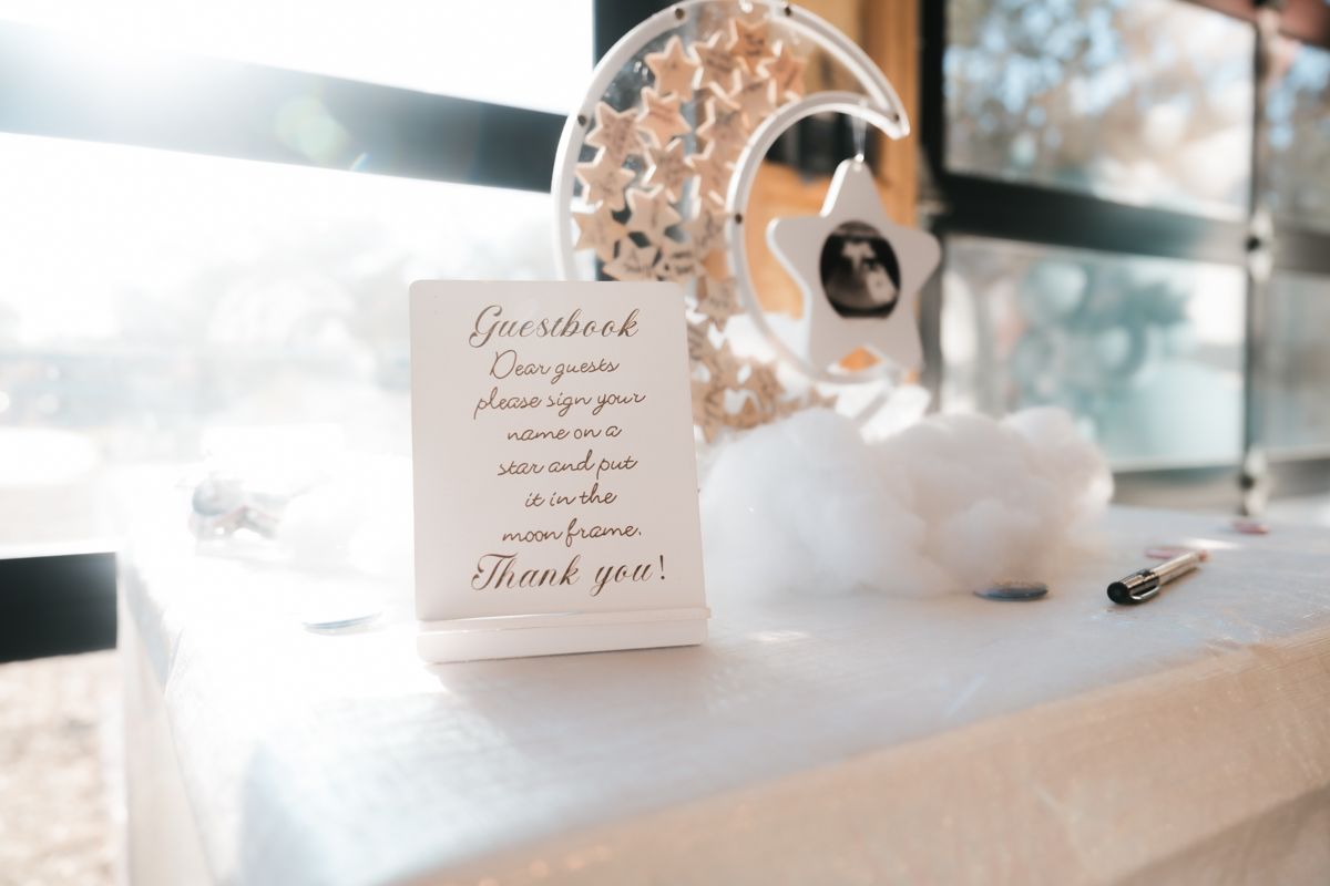 Elegant wedding thank you card displayed on white table with decorative elements.