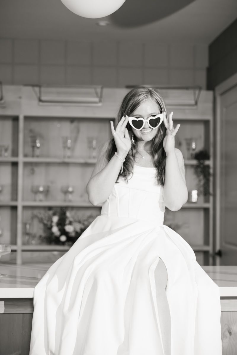 A fun bridal portrait with heart-shaped sunglasses in a modern venue.