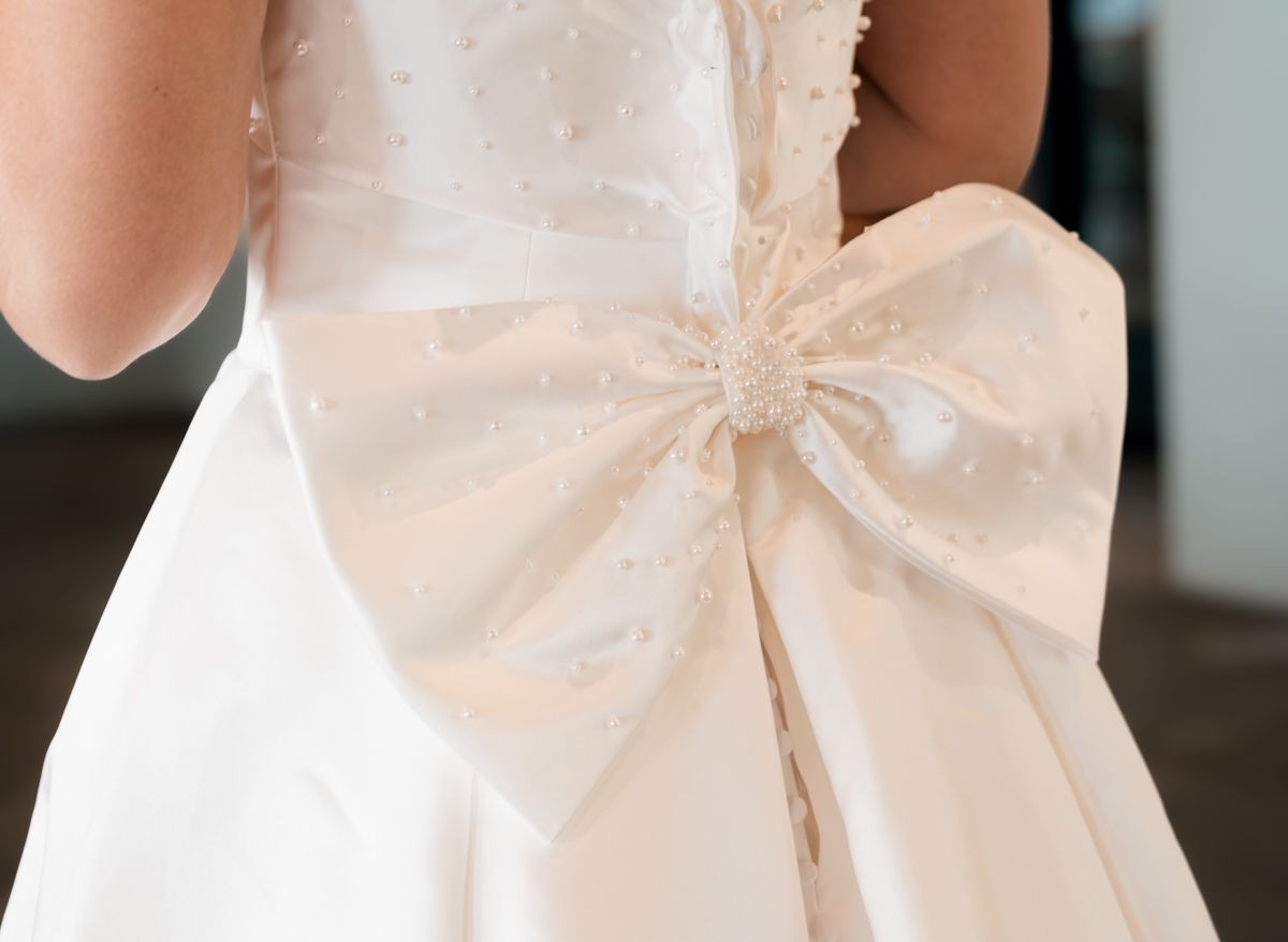 Elegant white satin bow detail on back of wedding dress.