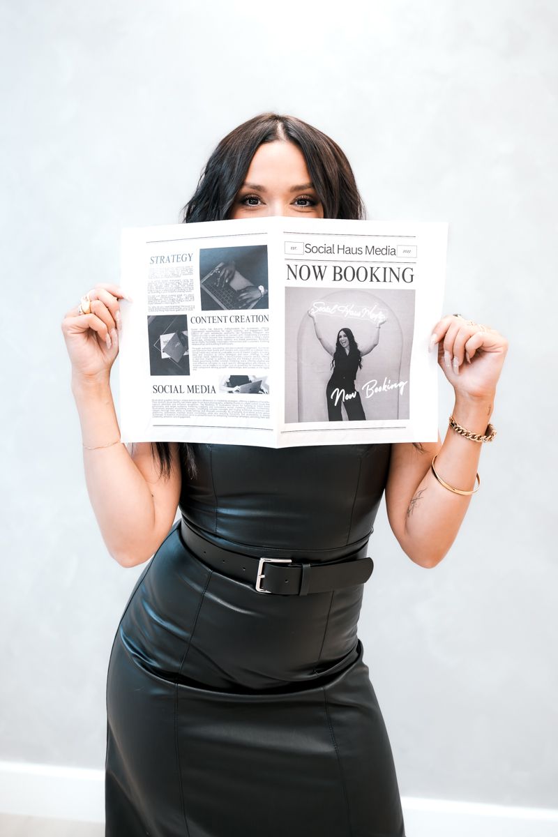 Professional marketing photo showing person holding newspaper advertisement.