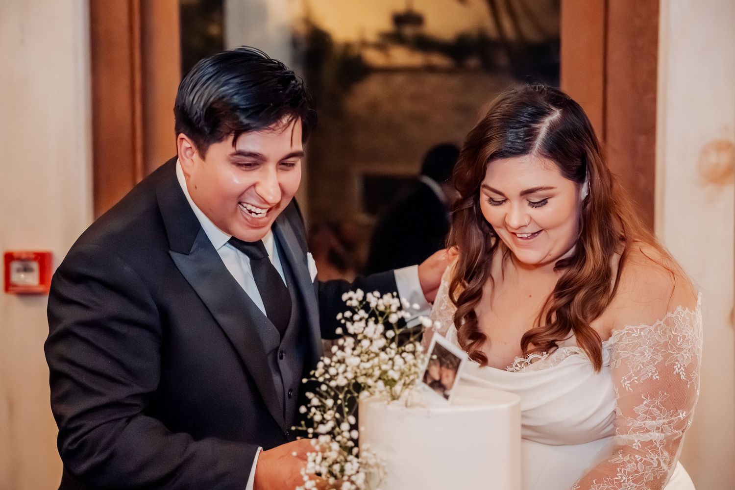 A bride and groom share a joyful moment holding baby's breath flowers during their wedding celebration.