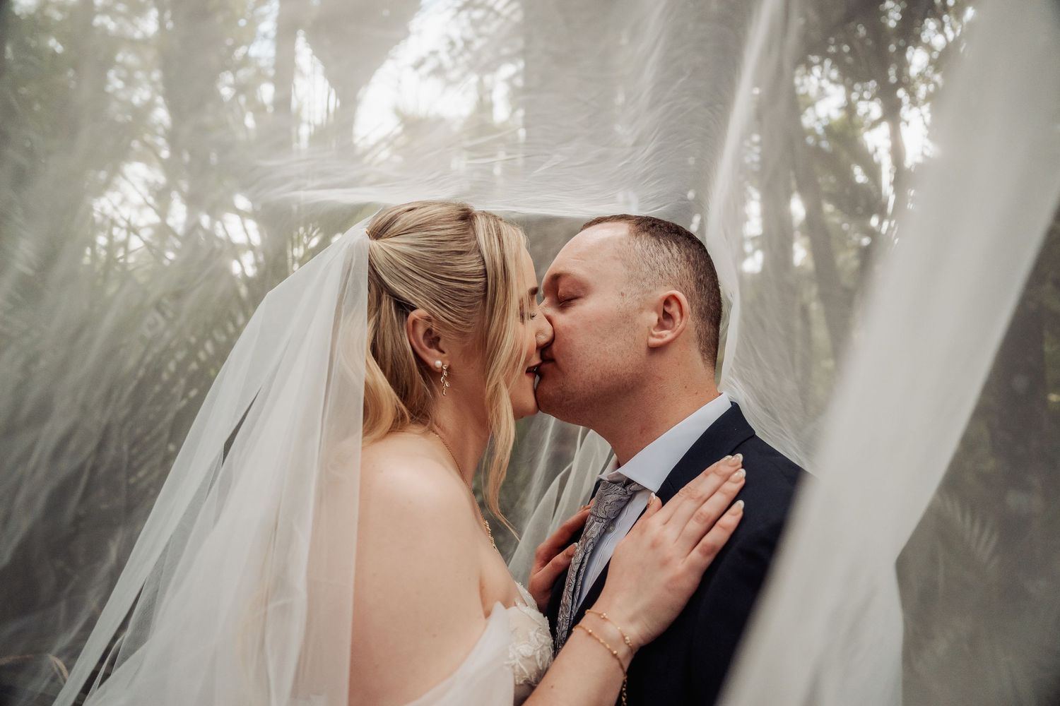Intimate wedding moment captured in misty forest setting.