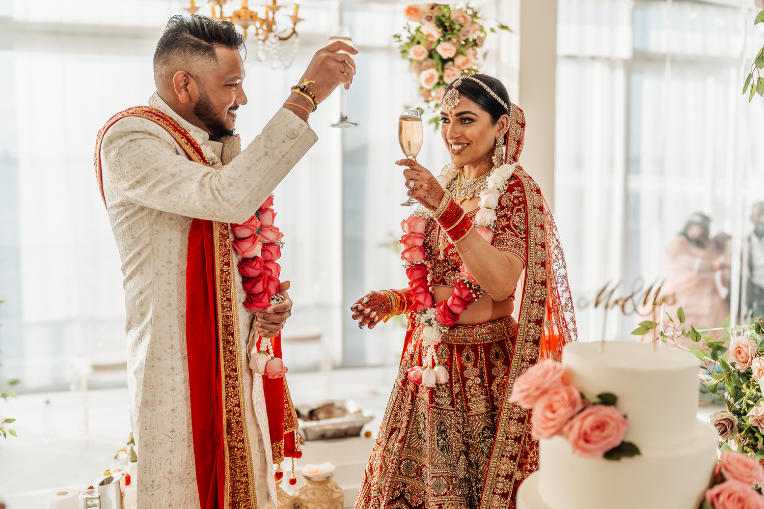Wedding ritual ceremony with couple in traditional Indian attire exchanging garlands.
