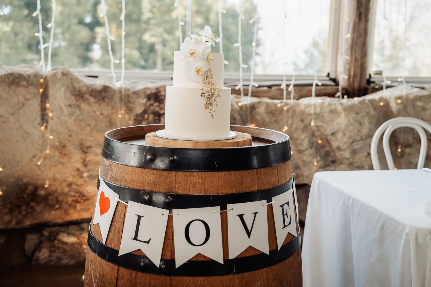 Wedding decor featuring rustic wooden barrels and romantic bunting with 'LOVE' text.