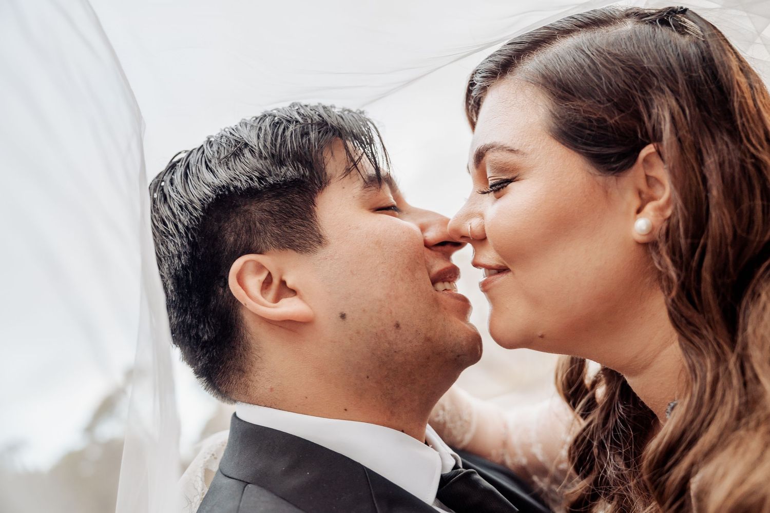 Close-up romantic wedding photos of couple sharing intimate kisses in black and white style.