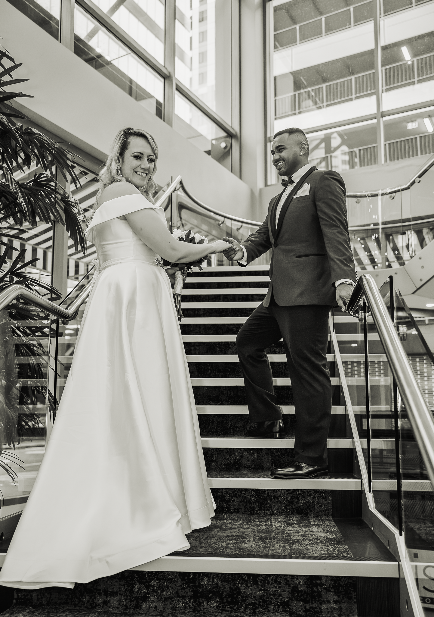 Black and white portrait of newlyweds on modern staircase.