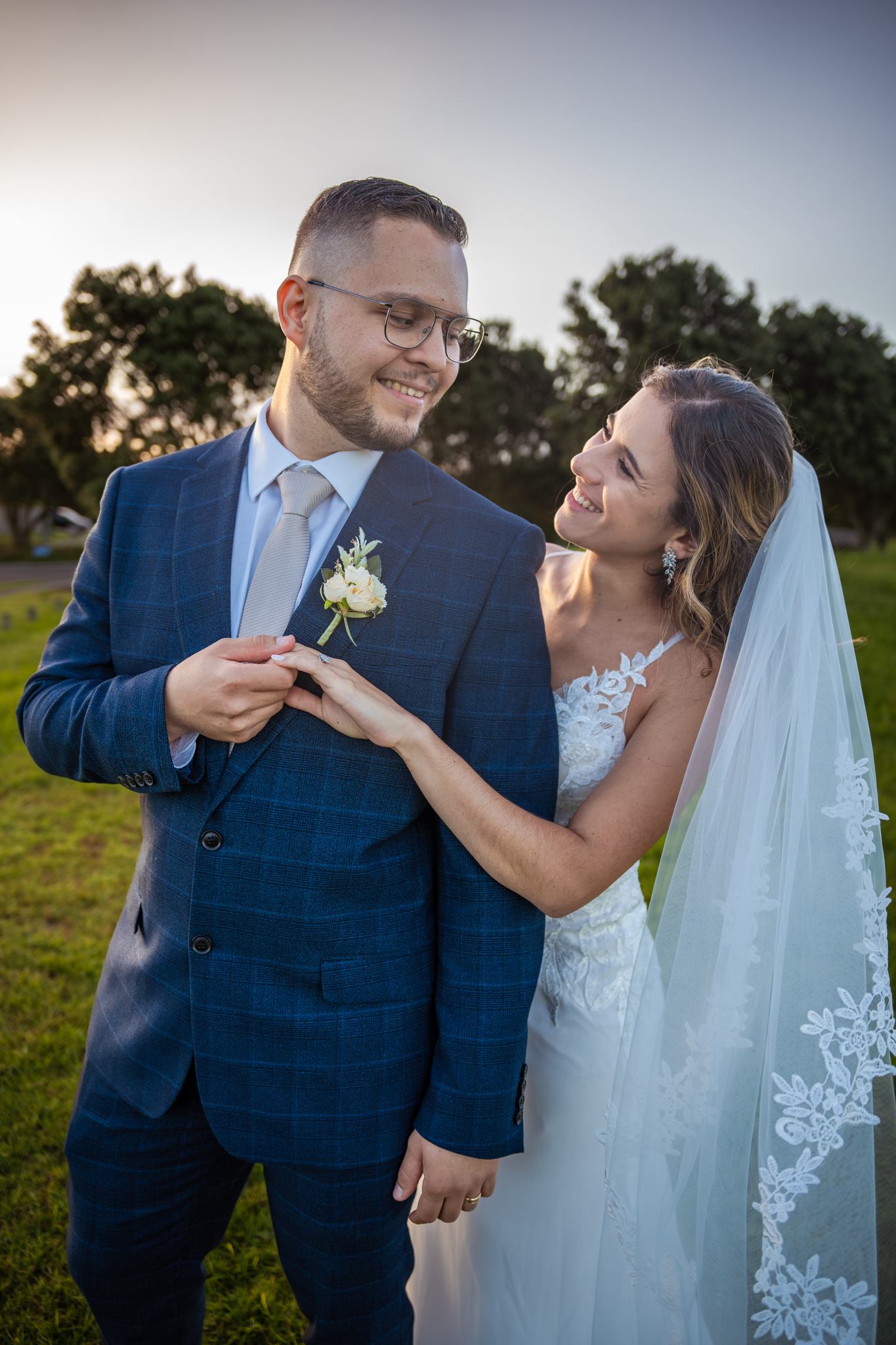 A wedding couple shares a joyful moment during sunset outdoors.