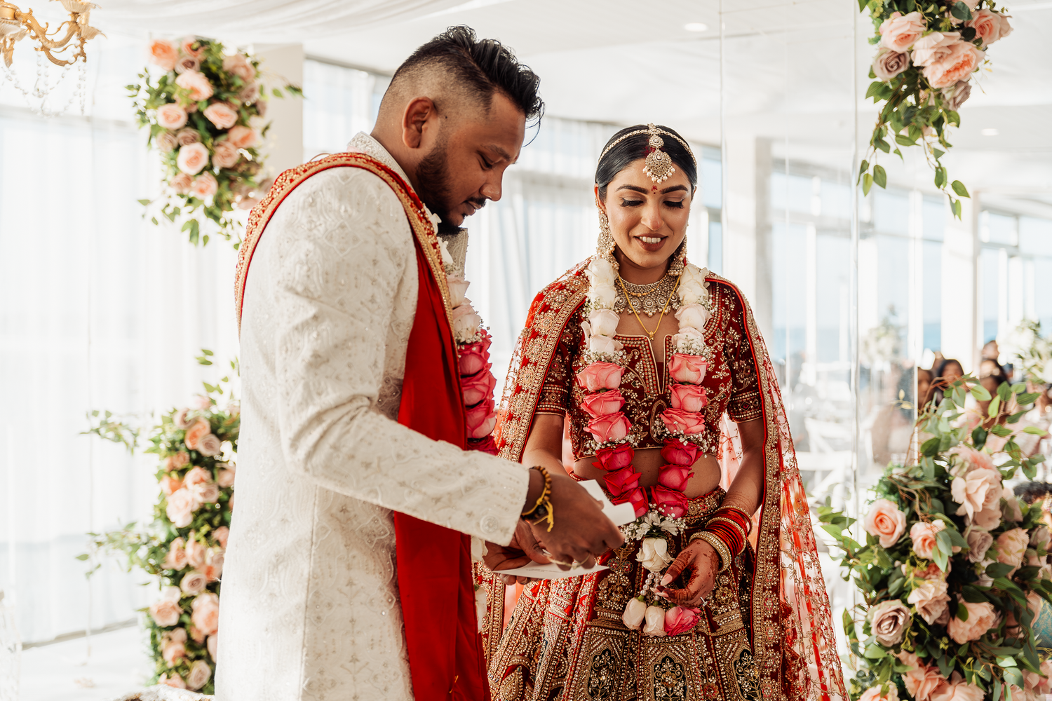 Traditional Indian wedding ceremony with couple performing rituals in elegant decor setting.