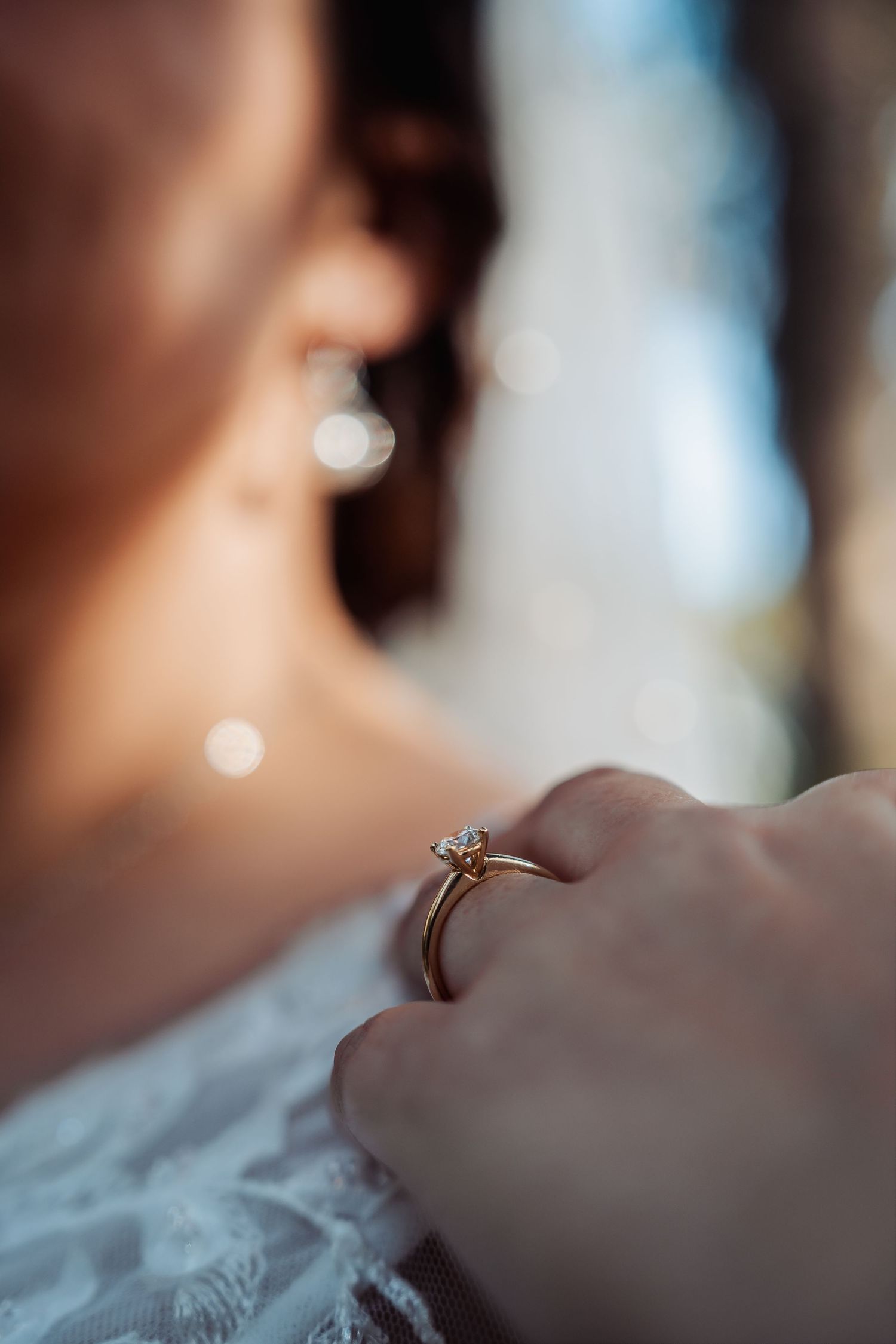 Close-up macro shots of an engagement ring with a diamond solitaire in soft focus.