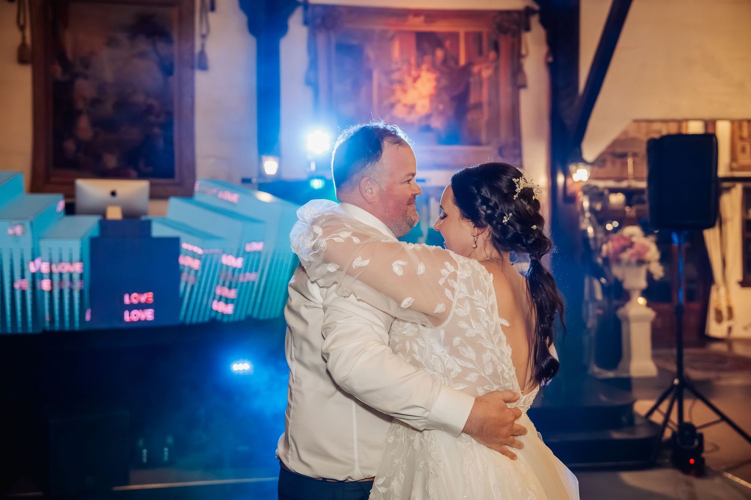 Dimly lit wedding reception dance floor with blue ambient lighting.