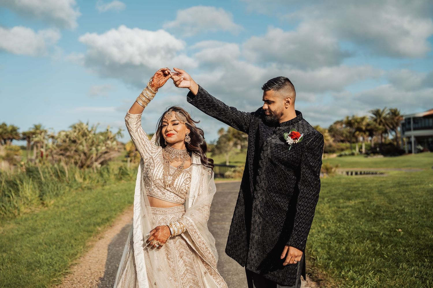 Wedding photography session in an outdoor setting with blue skies and green landscape.