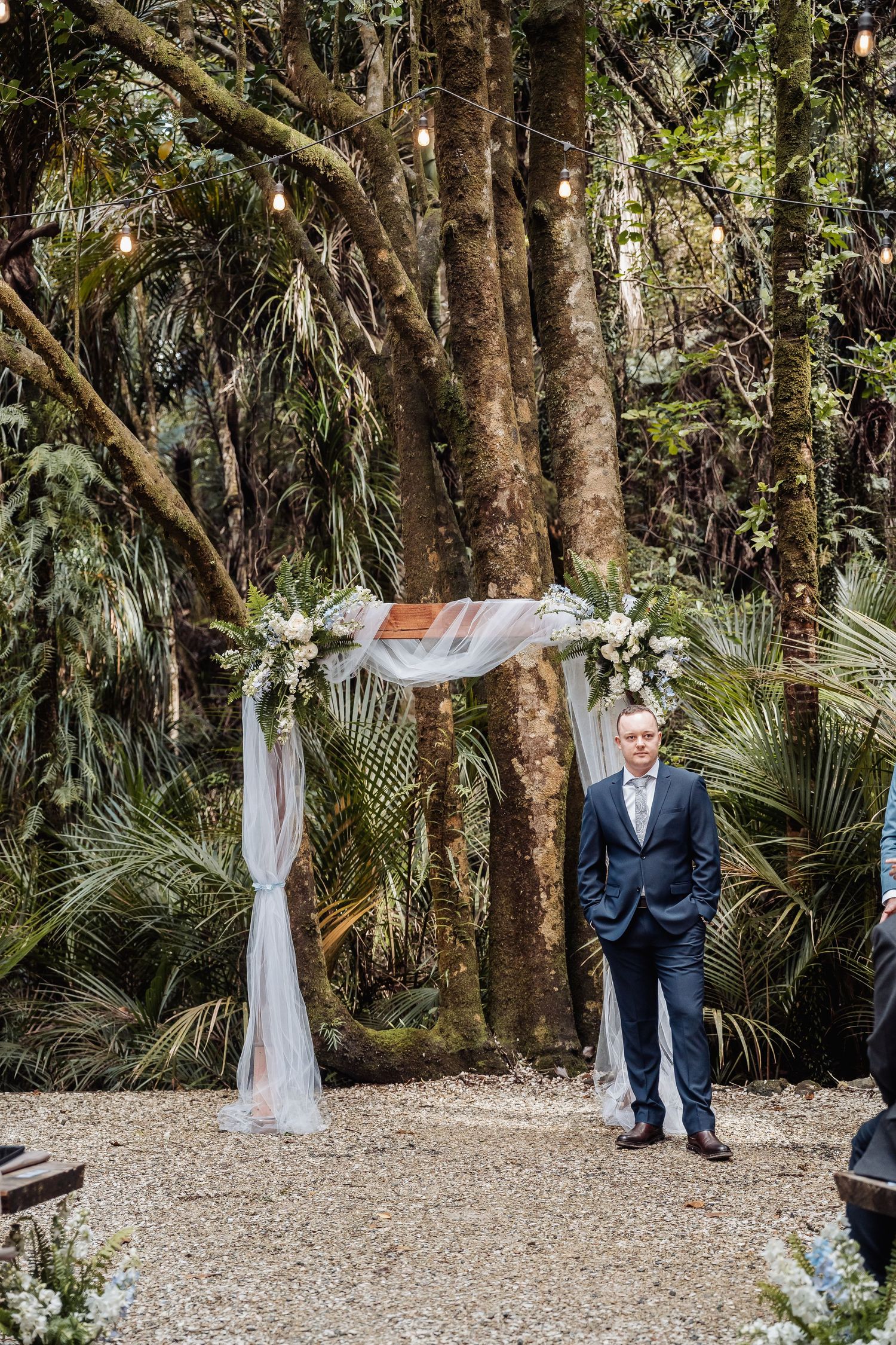 Outdoor wedding ceremony space with white drapes and tropical palm trees creating a natural backdrop.