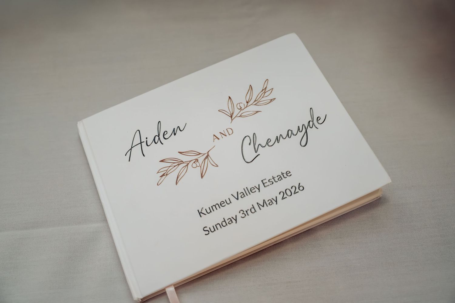 Elegant white wedding guest book for Aiden and Chenayde at Kumeu Valley Estate, Sunday 3rd May 2026.