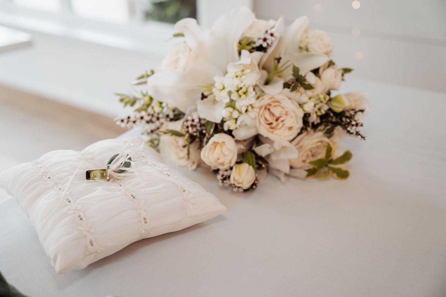 White floral napkin rings with delicate rose and baby's breath arrangements adorn a formal place setting.