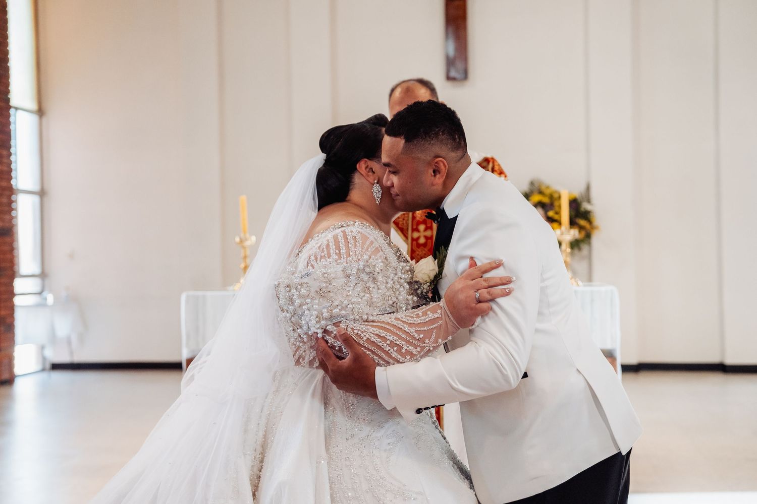 A beautiful wedding reception moment showing the couple sharing kisses and romantic embraces in front of wedding decor.