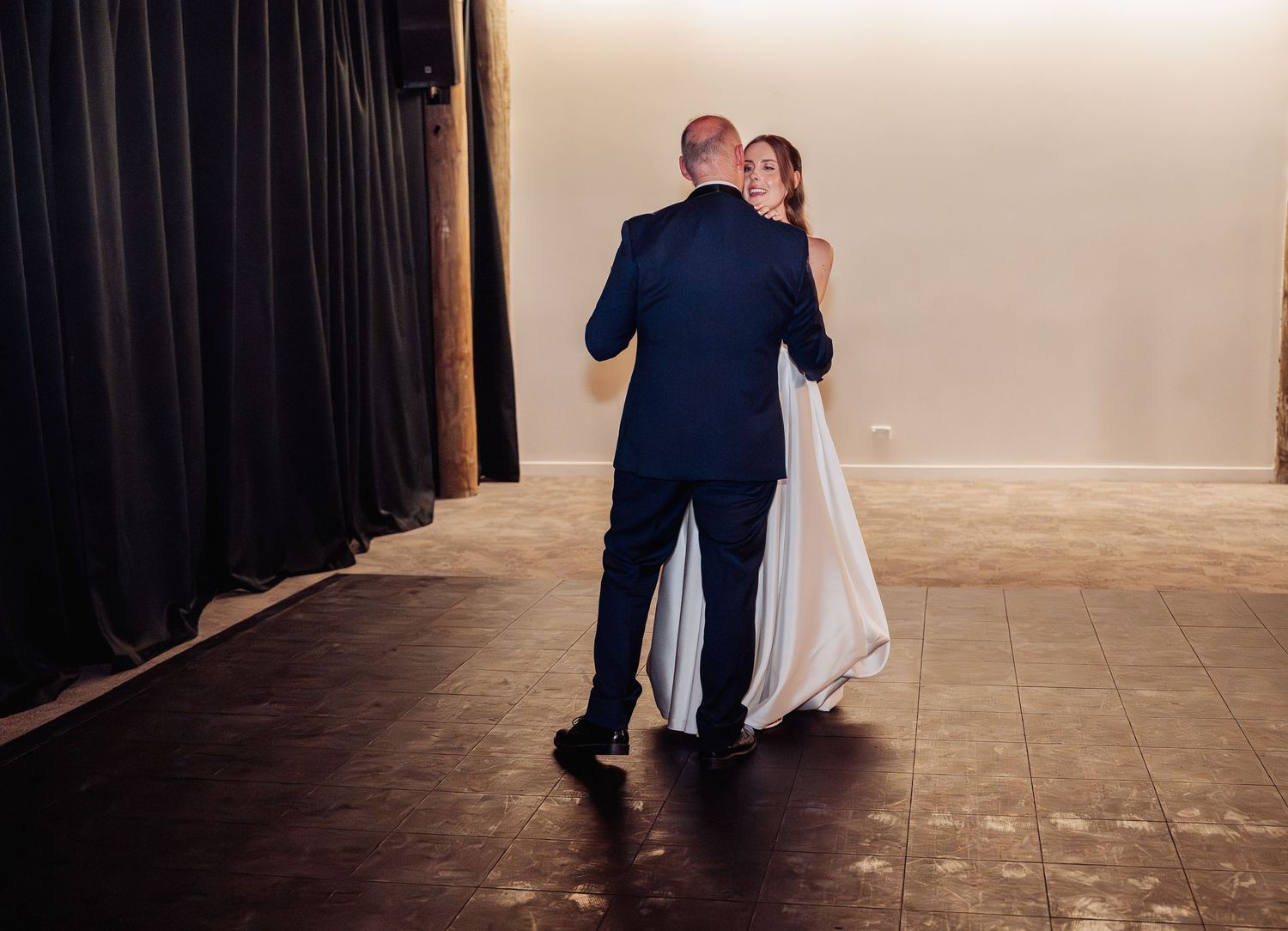 Bride and groom share their first dance together in an elegant venue during their wedding reception.