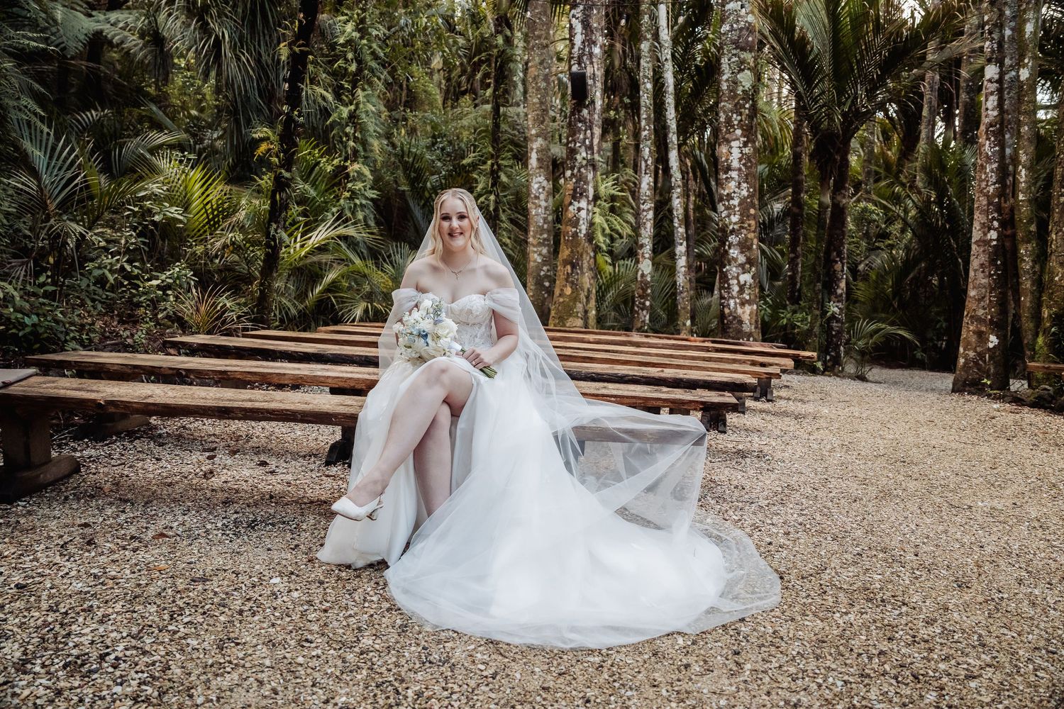 Wedding photography session in a rustic outdoor venue with wooden benches.