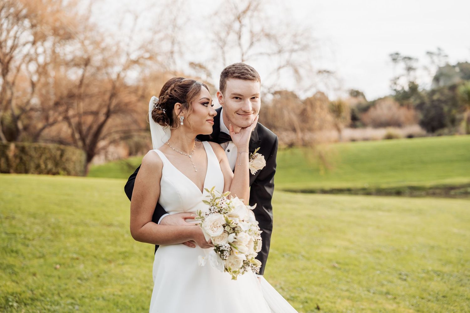A couple shares a tender moment during their outdoor wedding celebration.