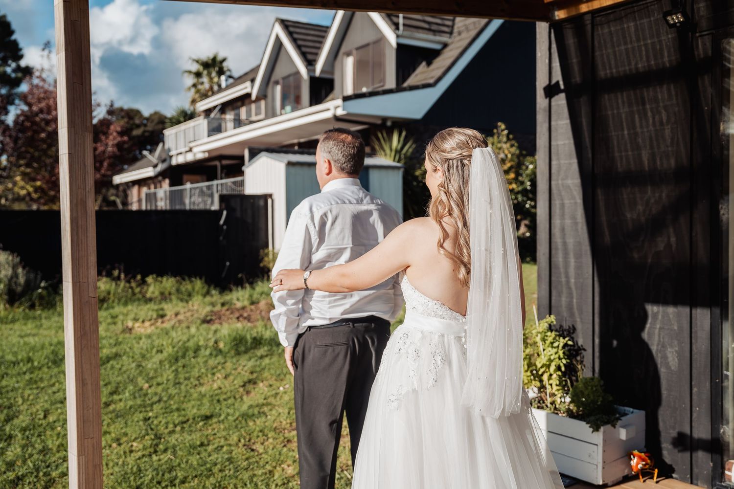 A bride and groom share a romantic moment together outside a rustic barn on their wedding day.