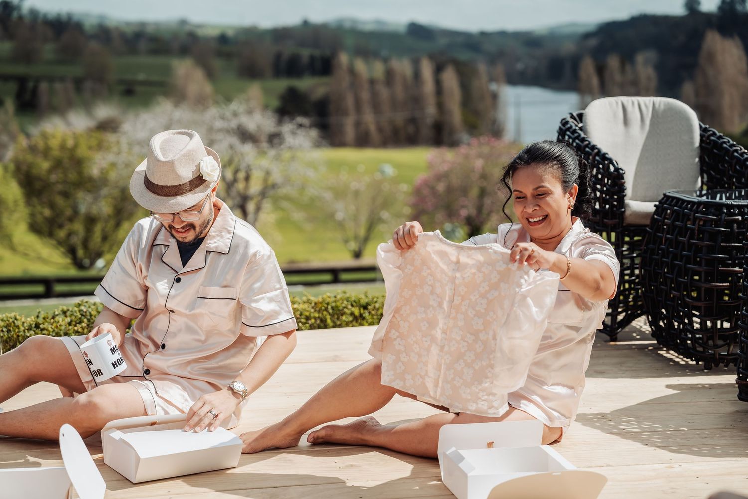 Wedding guests signing the guestbook at a rustic outdoor venue with scenic mountain views in the background.