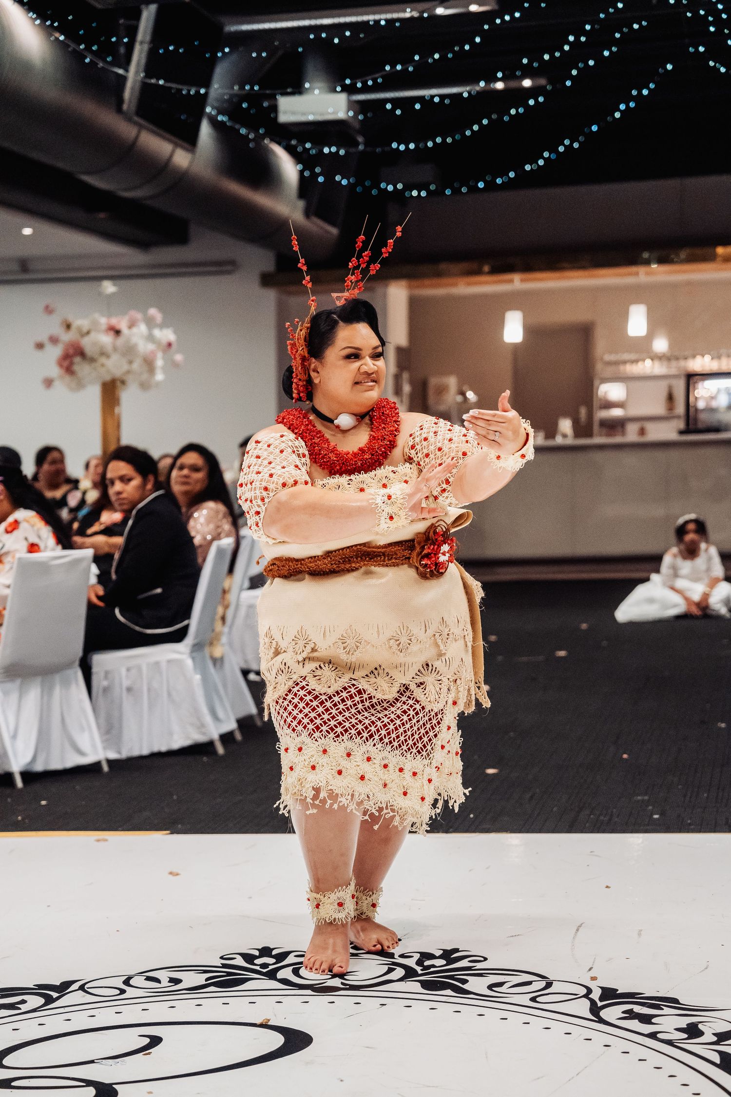 Traditional wedding reception dance floor with black and white pattern and twinkle lights overhead.