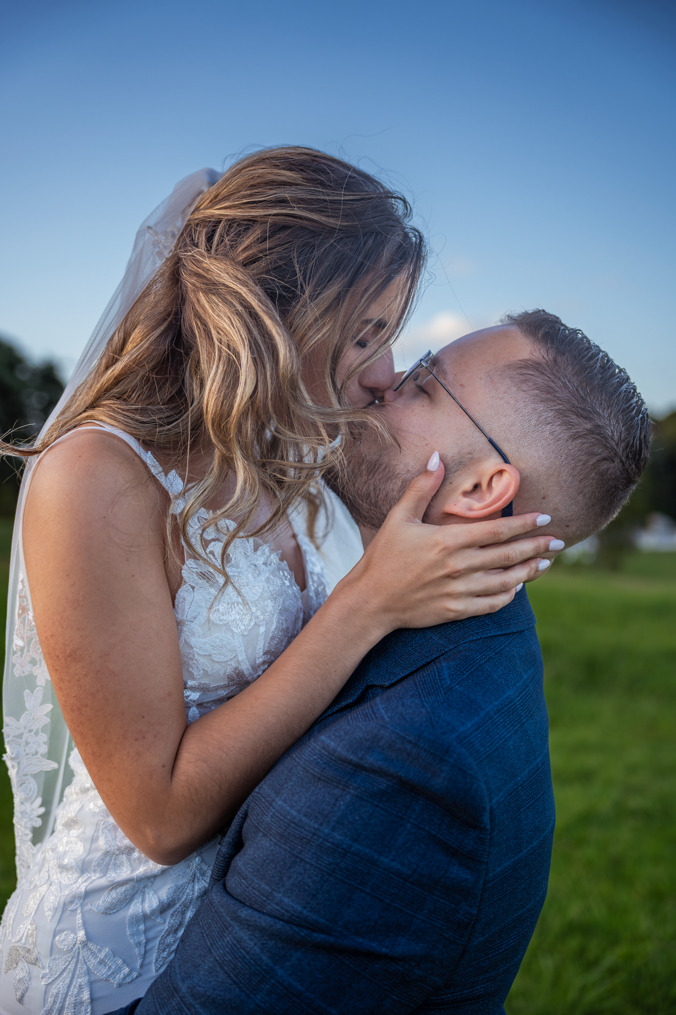 An intimate wedding moment captured during golden hour in a field.