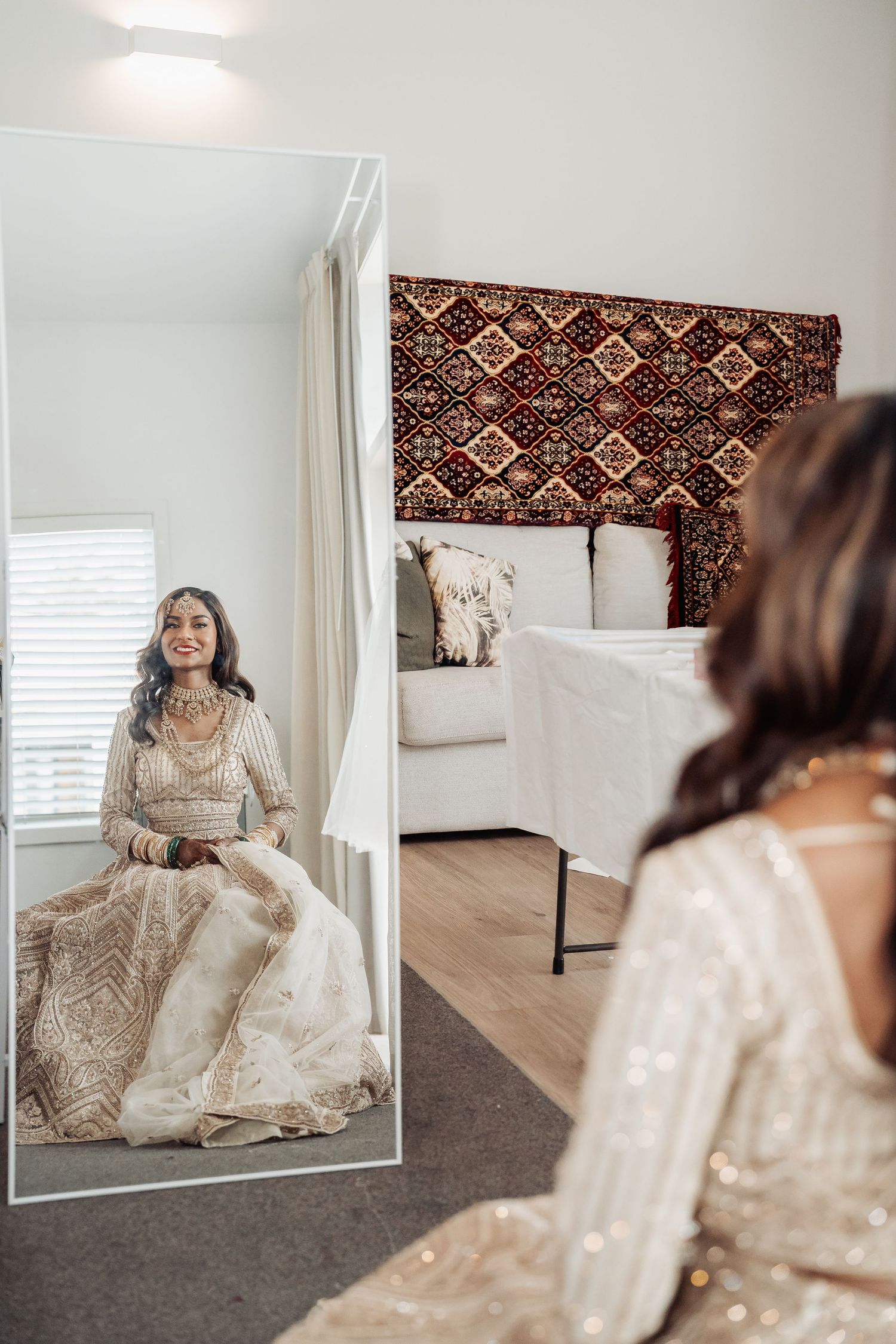 A series of mirror reflections showing a beaded cream-colored dress against a decorative tapestry background.