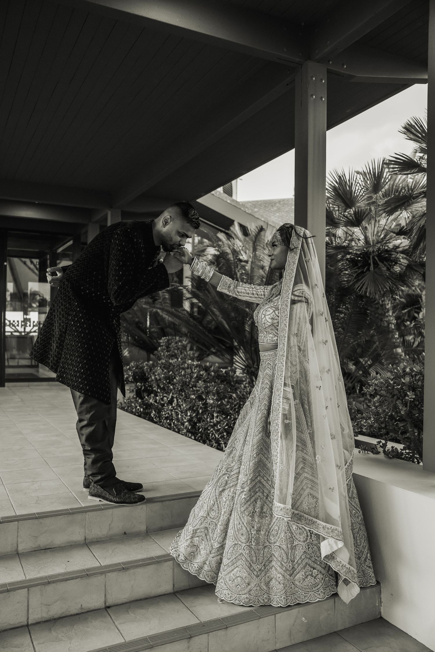Black and white wedding photography sequence showing the bottom of a bride's gown on an outdoor patio with palm trees.