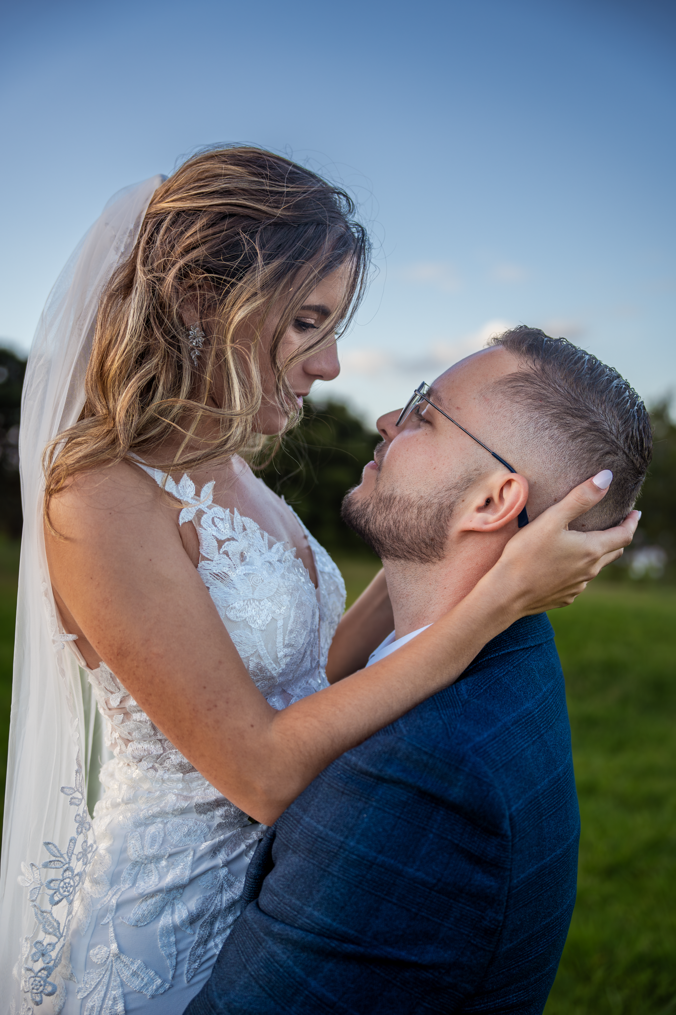A tender wedding moment shared between couple during sunset outdoors.