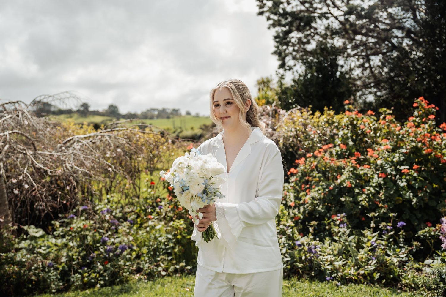 Elegant outdoor bridal portraits in a garden setting with blooming roses and natural scenery.