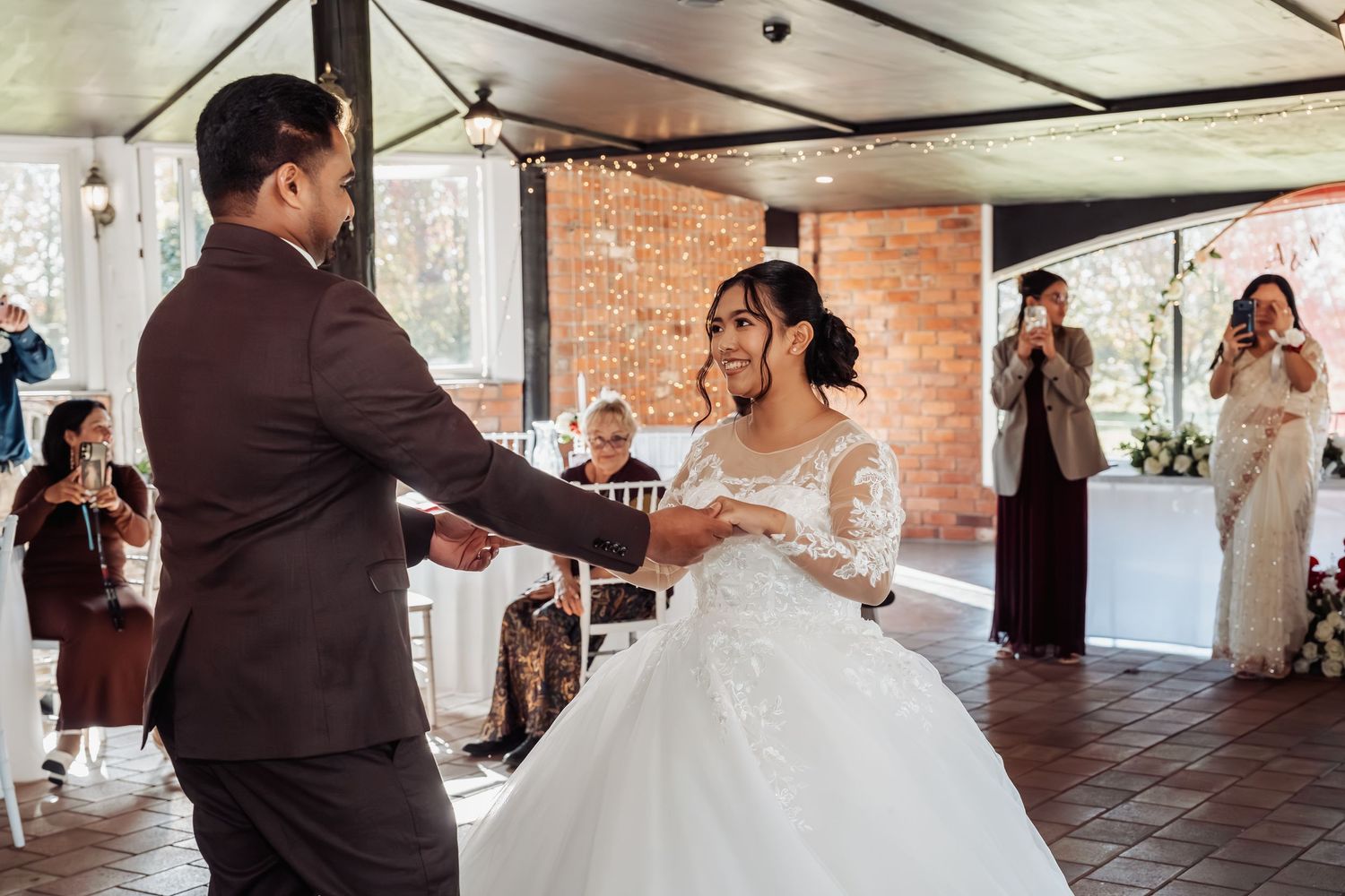 Bride and groom sharing their first dance while guests celebrate at an outdoor wedding reception.
