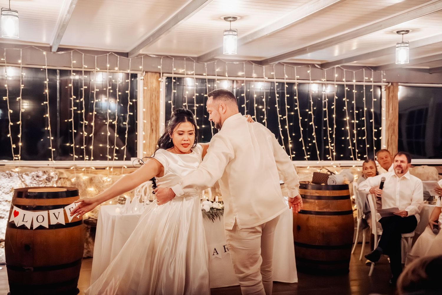 Wedding reception dance floor with string lights and elegant white decor.