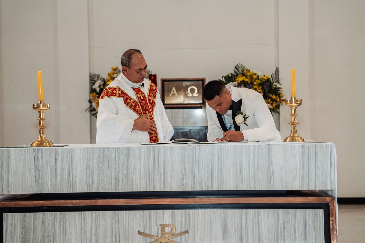 Elegant white altar decorated with candles and flowers for wedding ceremony.