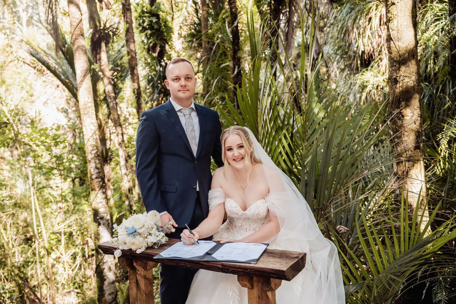 A wedding ceremony moment captured in a lush tropical garden setting.