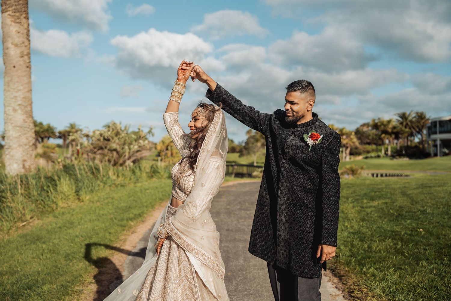 Couple poses together in formal attire against a scenic outdoor backdrop.