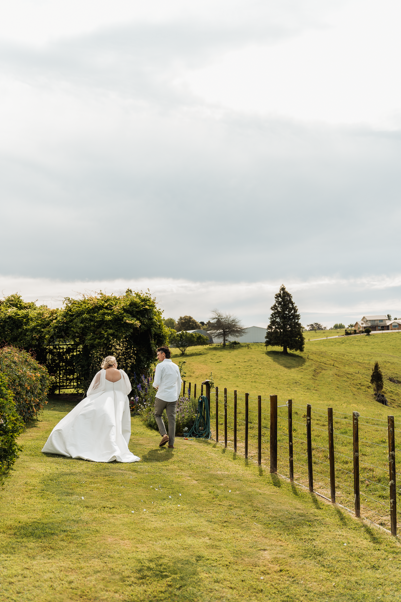 Couple walking along hillside path with scenic countryside views.