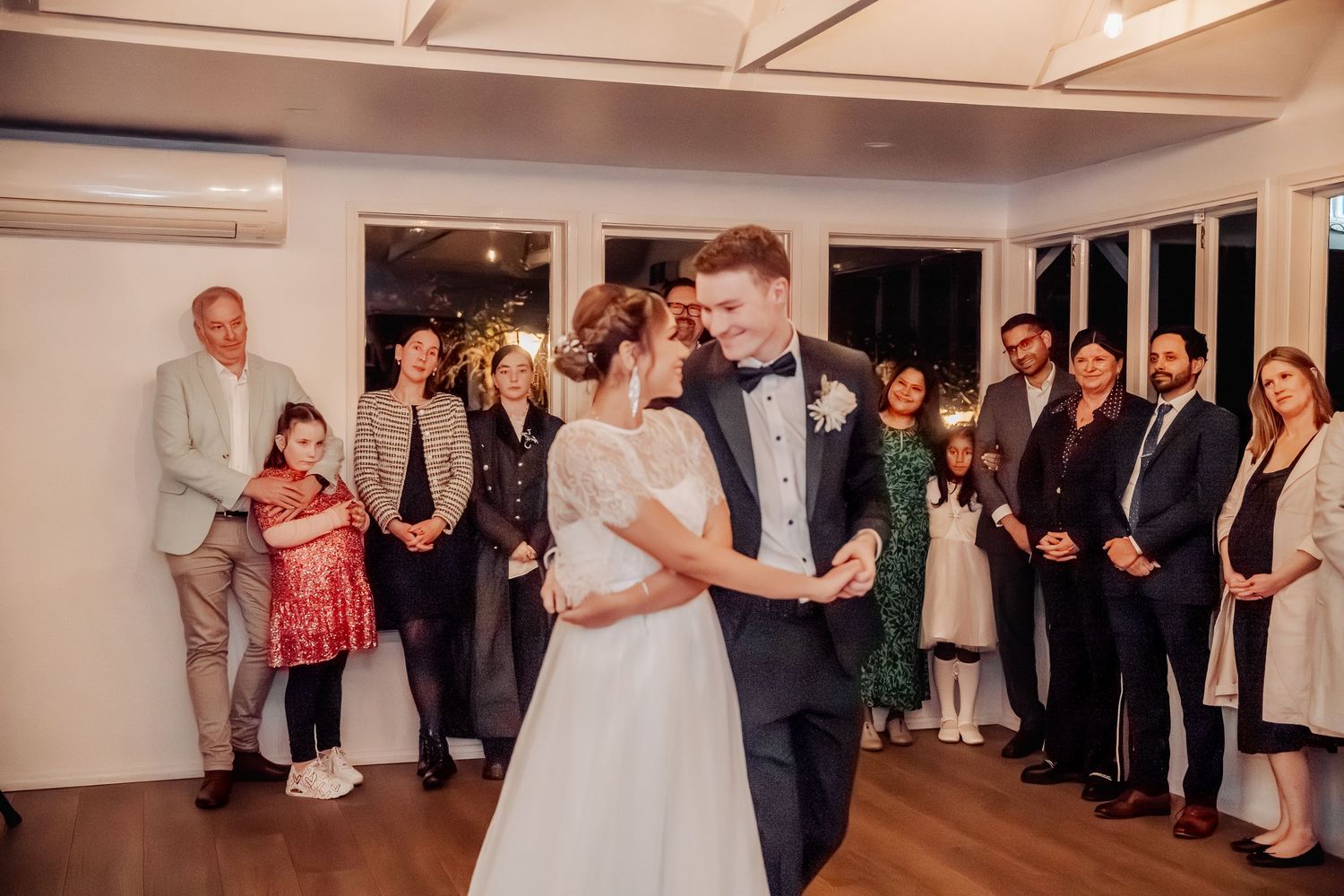Wedding reception dance floor filled with celebrating guests in formal attire.