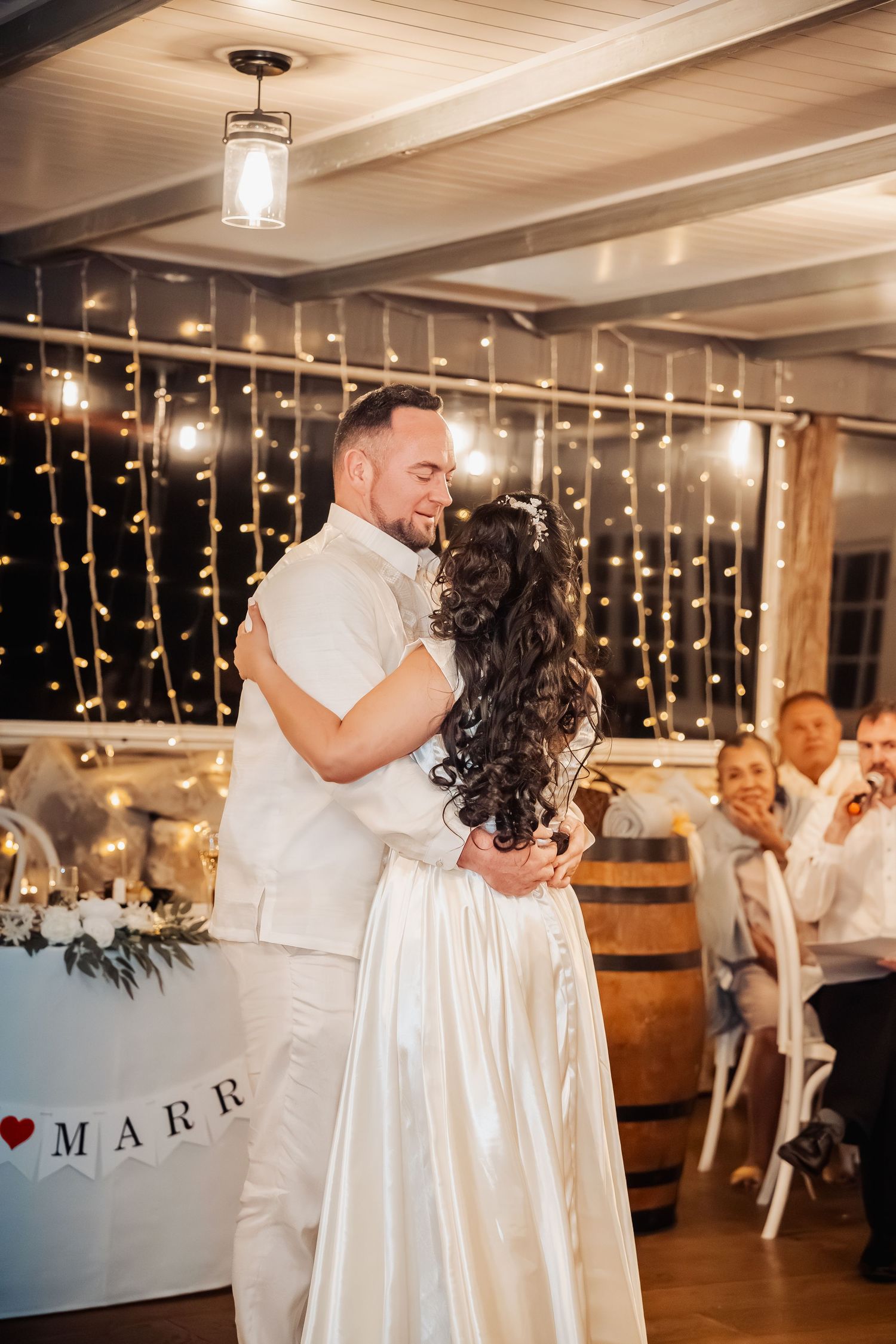 Wedding celebration in elegant indoor venue with twinkle lights and romantic atmosphere.